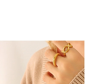 Detail showing two gold plated rings with twisted and textured designs on a finger
