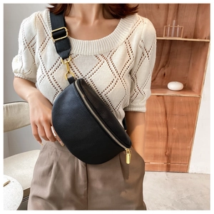 Detailed view of black lychee grain leather waist bag with gold zipper on wide strap
