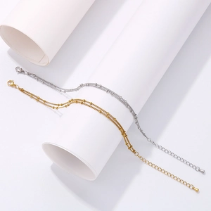 Detailed macro of gold and silver double-layered bead chain bracelet with lobster clasp