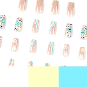 Hand-painted press-on nails featuring smiley faces, rainbow waves, and daisy floral designs
