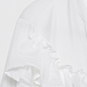Blouse blanche élégante à col en V avec détails à volants aux épaules et tissu texturé