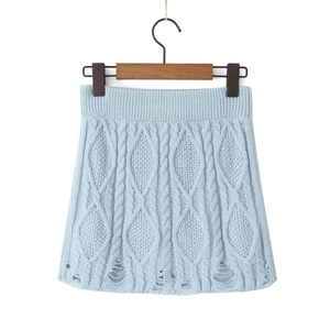 Detail showing light blue cable knit mini skirt with distressed ripped hemline detail