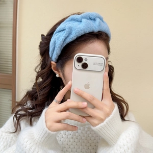 Close-up of soft light blue knitted headband with textured twist on a female model