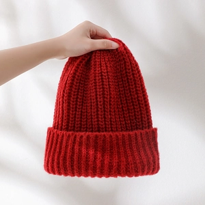 Close-up of a cozy red chunky knit winter hat with a ribbed cuff for a festive look