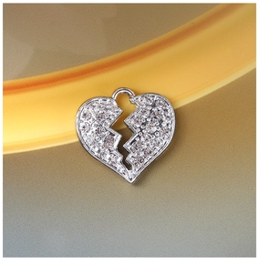 Macro detail of a silver broken heart pendant with clear rhinestones for DIY jewelry