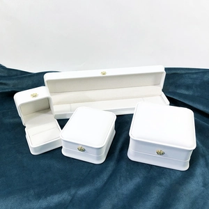 Macro shot of white PU leather jewelry boxes with elegant golden crown emblem detail