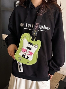 Guitar-shaped crossbody bag in green and white with pink bat wings and star rivets