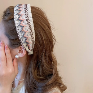 Détail de la broderie en point de chaînette colorée et de la texture tissée du serre-tête