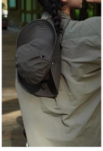 Detail of outdoor sun hat with wide brim, metal vents, and adjustable windproof cord