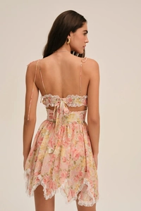 Détail du dos d'une robe fleurie rose avec rubans lacés et bordure en dentelle