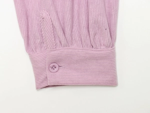 Detaillierte Nahaufnahme der rosa Cord-Ärmelmanschette mit einzelnem Harzknopfverschluss