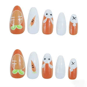 Detail of long almond press-on nails with cute Easter bunny and carrot designs in orange and white