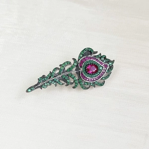 Elegant silver feather brooch with green and rose crystals on vintage black metal base