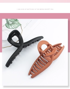 Detail of matte finish hair claw clips in black and terracotta with twisted knot design