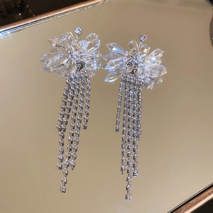 Macro view of crystal flower earrings with sparkling silver diamond fringe tassels