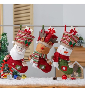 Trois chaussettes de Noël tricotées avec motifs Père Noël, renne et bonhomme de neige