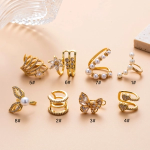 Set of eight gold ear cuffs featuring zircon butterflies, pearls, and floral designs
