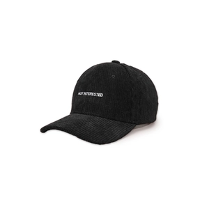 Detail of NOT INTERESTED embroidery on black corduroy baseball cap with ribbed texture