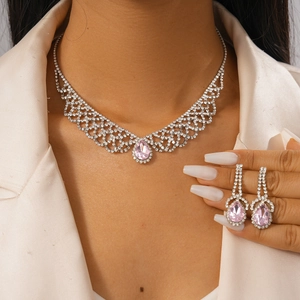 Macro shot of sparkling pink pear-cut rhinestone necklace and earring jewelry set on model