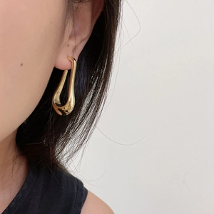 Close-up of woman wearing a minimalist 18K gold plated U-shaped geometric earring