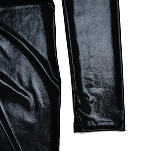 Détails du tissu en maille enduit noir brillant et des plis latéraux de la robe