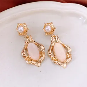 French vintage gold earrings with pink shell oval pendant and pearl studs on a white tray