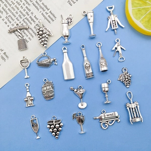 Flat lay of wine-themed silver metal charms featuring bottle and goblet detail