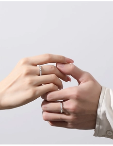 Close-up of S925 sterling silver couple rings featuring pavé zircons and minimalist lines