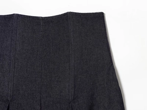 Macro view of high-waist dark blue denim jeans showing stitching and fabric texture