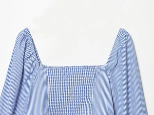 Détail du haut rayé avec col carré, smocks élastiques et finitions de qualité