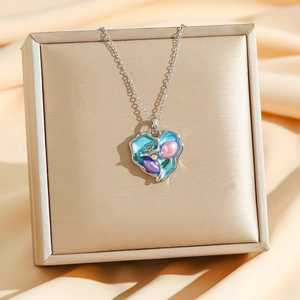 Vintage heart pendant necklace with natural pearls on a gold box and silk background