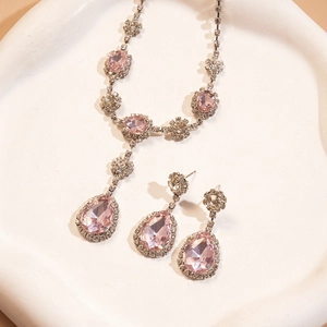 Détail macro du collier et des boucles d'oreilles sertis de pierres roses en poire