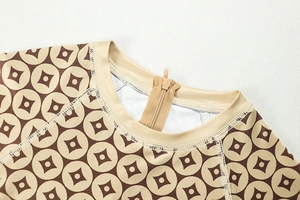 Detail of the crew neck collar with zipper closure and raglan sleeve stitching on jumpsuit