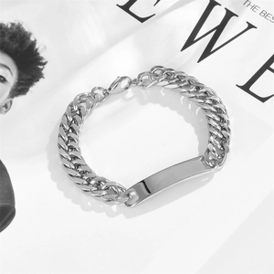 Men's silver stainless steel Cuban link bracelet with rectangle ID tag on magazine