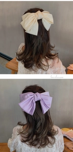 Vue détaillée de grandes pinces à cheveux noeud en satin crème et violet lavande