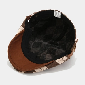 Detail of checkered flat cap showing inner lining, black sweatband and care label
