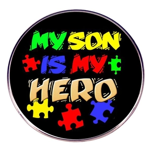 Macro detail of Autism Hero pin badge with colorful puzzle pieces and silver metal frame