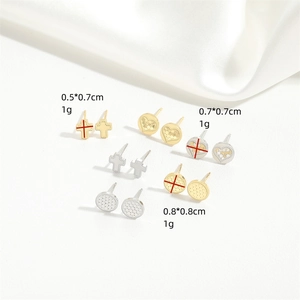 Set of minimalist cross stud earrings in gold and silver finish on white silk