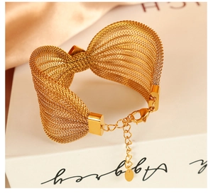 Macro detail of golden mesh bow bracelet showing lobster clasp and adjustable chain