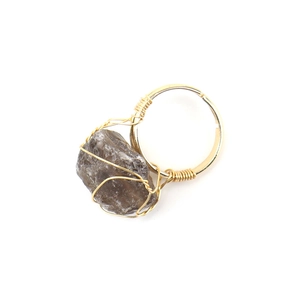 Detailed macro view of handmade gold wire-wrapped raw agate stone adjustable ring