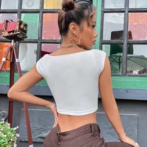 Close-up of white ribbed crop top showing slim fit cut and textured knit fabric detail