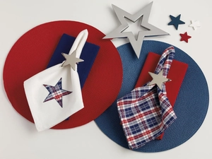 Detail of round woven placemats with star napkin rings for patriotic table setting