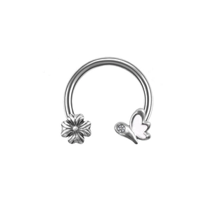 Detail of horseshoe ring with silver flower and white butterfly featuring a zircon stone