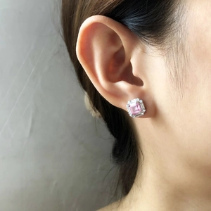 Close-up of pink square sugar stone earring with halo setting worn on earlobe