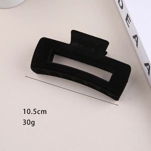 Close-up of black flocked hair claw clip measuring 10.5cm with elegant matte texture