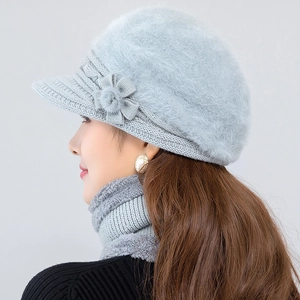 Detailed close-up of light blue knit winter hat with faux fur trim and floral decoration