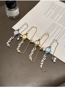 Detail of elegant pearl strap watches in gold and silver finish on vintage books