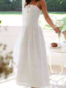 White sleeveless maxi dress featuring a cinched waist, drawstring, and button-down detail