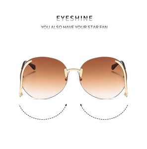 Front detail of rimless oversized sunglasses with brown gradient lenses and gold metal trim