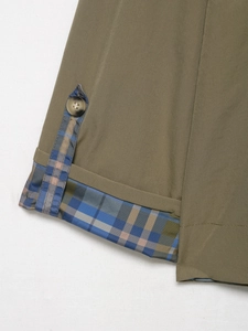 Detailed close-up of plaid cuff with button strap and contrasting checked lining